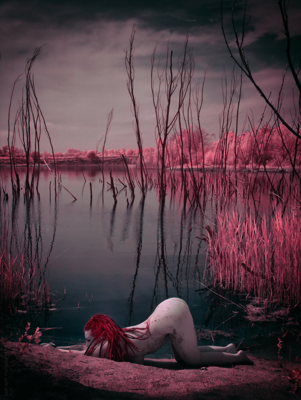 Nahá dívka u jezera s vystrčeným zadkem.